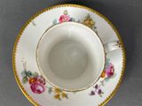 a cup and saucer on a table with a gray background