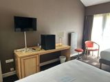 a bedroom with a bed, desk and television in it