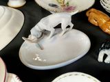 a table topped with plates and bowls with figurines of animals