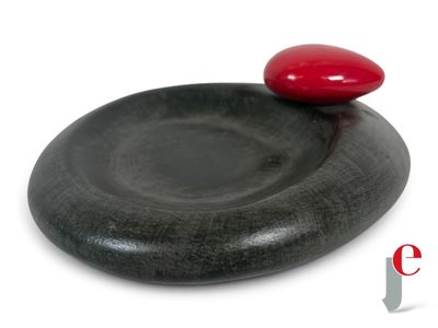 une pierre noire surmontée d'une pierre rouge