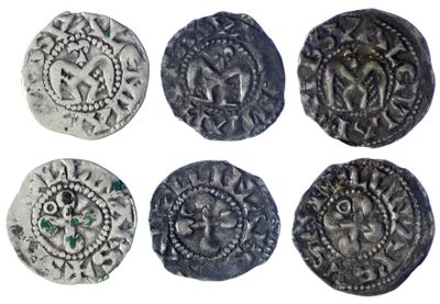 six pièces d'argent anciennes ornées de motifs sur fond blanc