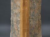 an old book sitting on top of a table covered in paper