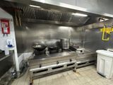 une grande cuisine en inox équipée d'une cuisinière et d'un évier