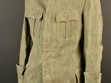 an army uniform on a mannequin stand against a black background