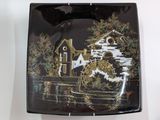 a black plate with a picture of a mill on it