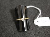 une bague sertie d'un diamant, posée à côté d'une étiquette de prix