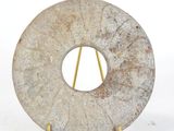 a stone sculpture of a circular object on a stand