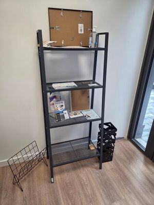 une bibliothèque dans un coin d'une pièce avec une fenêtre