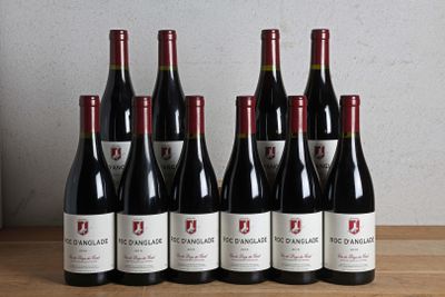 six bottles of red wine are lined up on a wooden table