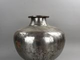 a silver vase that is sitting on a table