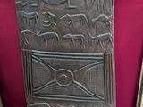 une vieille porte en bois ornée de sculptures, devant une bibliothèque