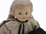 a doll that is sitting next to a doll that is wearing a hat