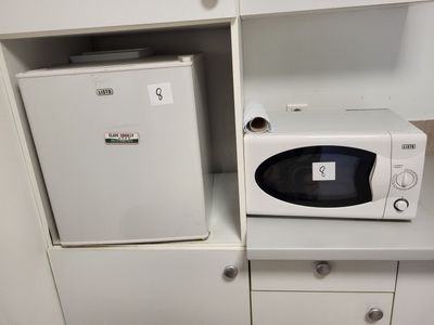 a microwave and a small refrigerator in a small room