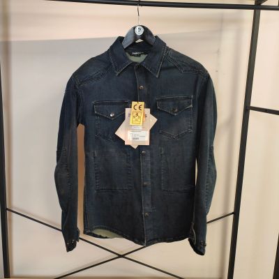 une veste en jean accrochée à un portant dans un magasin de vêtements