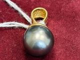 an image of a black pearl pendant on a red cloth