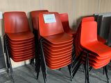 several red chairs are lined up against a wall with a sign on them