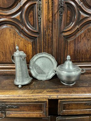 une photo d'un meuble en bois sur lequel sont posés deux plats en argent