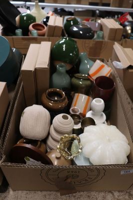 une boîte remplie de vases posée par terre dans une pièce