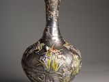 a silver vase with a dragon on it on a table