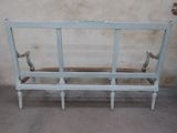 a white bench with a wooden seat in the corner of a room