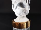 une figurine blanche posée sur un socle doré