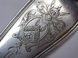 a silver spoon with a design on it sitting on a table