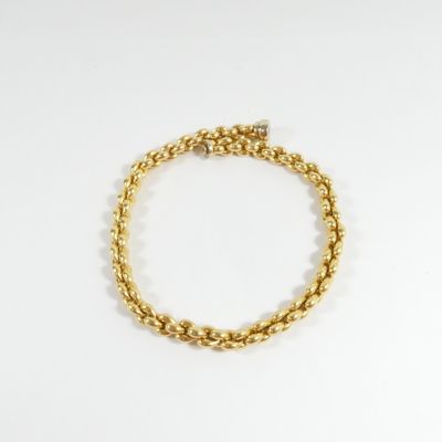 gros plan d'un bracelet en or sur fond blanc