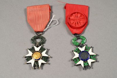 two medals with a red ribbon and a gold medal on a gray surface