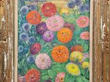 une peinture à l'huile représentant des fleurs, dans un cadre doré, accrochée au mur