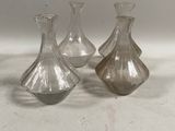 trois vases en verre posés sur une table