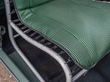 a green chair with a green seat cushion in the back of a truck