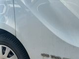 a small white car parked on the side of the road
