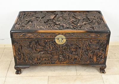 a wooden box with carvings on it sitting on a tile floor