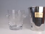 a silver ice bucket and a clear glass on a table