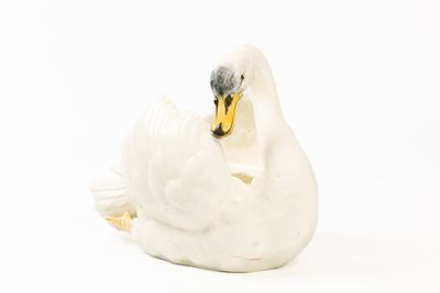 une figurine de cygne blanc posée sur une surface blanche