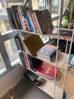 une bibliothèque remplie de livres, placée devant une fenêtre