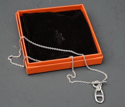 une boîte orange à laquelle est attachée une chaîne argentée