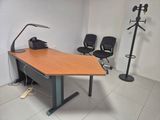 a desk with a lamp and two chairs in a room