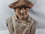 buste d'un homme portant un chapeau et une écharpe autour du cou