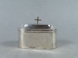 une petite boîte en argent surmontée d'une croix