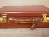 a brown suitcase sitting on a table with a key in it