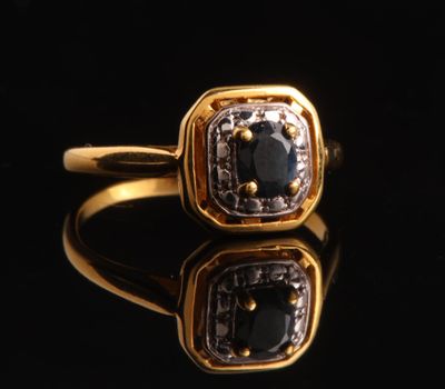 gros plan d'une bague en or avec des diamants noirs et blancs