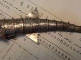 un poisson en métal posé sur une feuille de papier