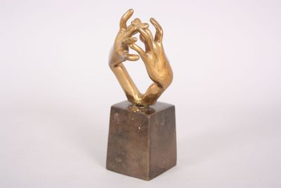 statue of two hands holding each other on a marble block