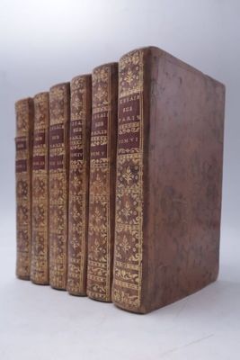 four books are lined up in a row on a white surface
