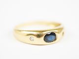 gros plan d'une bague en or avec une pierre bleue