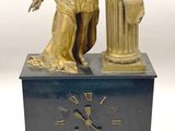 une statue représentant un homme tenant un globe terrestre et une horloge