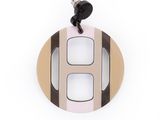 un gros plan d'un pendentif circulaire blanc et noir sur fond blanc