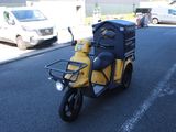 un scooter jaune et noir garé sur le bord de la route