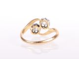 a close up of a gold ring with two hearts on it